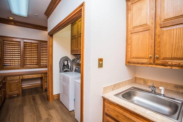 laundry area featuring sink, crown molding, dark hardwood / wood-style floors, cabinets, and independent washer and dryer