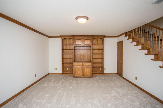 unfurnished living room with ornamental molding and light carpet