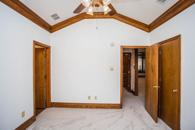 carpeted spare room featuring crown molding, ceiling fan, and lofted ceiling