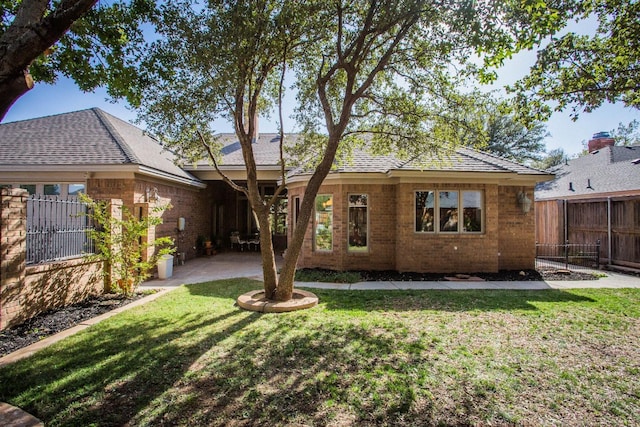 back of house featuring a lawn and a patio