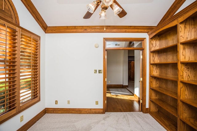 carpeted spare room with crown molding and ceiling fan