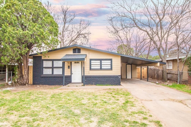 view of front of house featuring a carport and a lawn