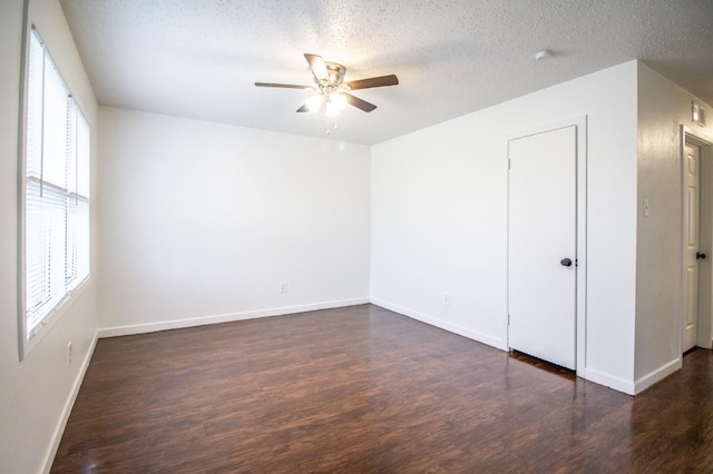 empty room featuring ceiling fan, a textured ceiling, and dark hardwood / wood-style flooring