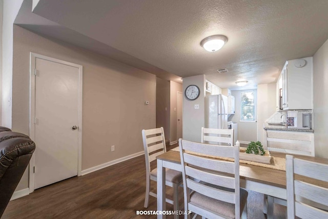 dining space featuring dark hardwood / wood-style floors and a textured ceiling