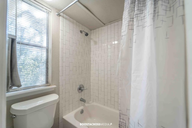 bathroom featuring shower / bath combination with curtain and toilet