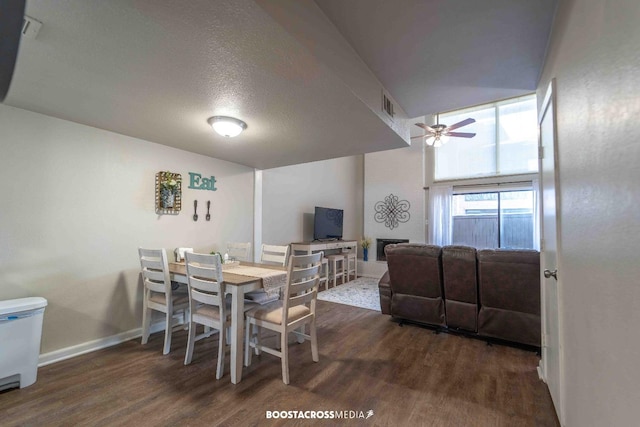 dining space with ceiling fan, dark hardwood / wood-style floors, and a textured ceiling