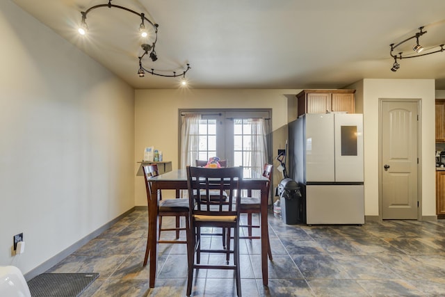 6208 21st St, Lubbock, TX 79407 - dining room featuring baseboards, stone finish flooring, and track lighting