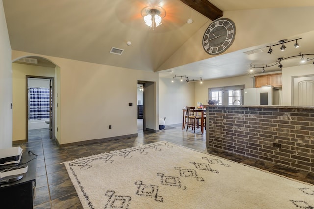 6208 21st St, Lubbock, TX 79407 - living area featuring lofted ceiling with beams, visible vents, baseboards, ceiling fan, and arched walkways