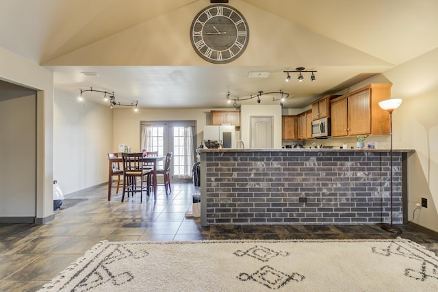 6208 21st St, Lubbock, TX 79407 - kitchen with stainless steel microwave, a peninsula, refrigerator, track lighting, and vaulted ceiling