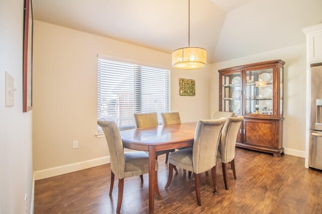 dining area featuring dark wood-type flooring and vaulted ceiling