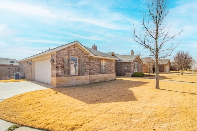 single story home with a garage and central AC unit