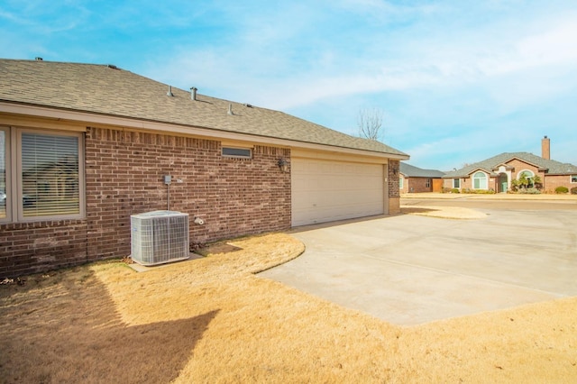 view of side of home with central AC unit and a garage