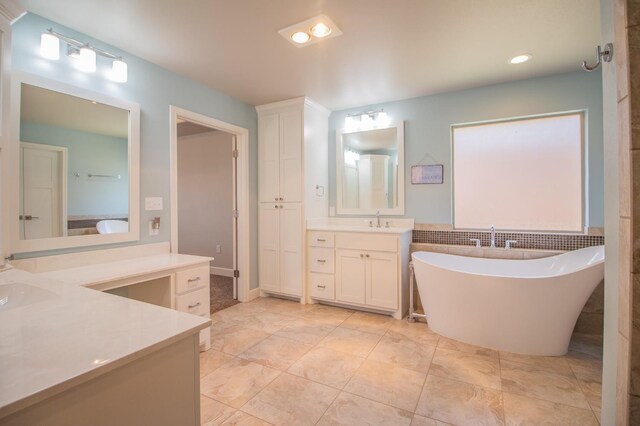 bathroom with a tub to relax in and vanity