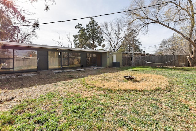 view of yard with central AC unit and a fire pit