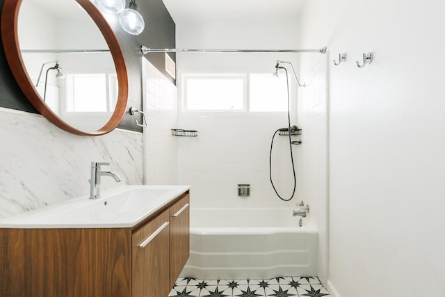 bathroom featuring tiled shower / bath, vanity, and tile walls