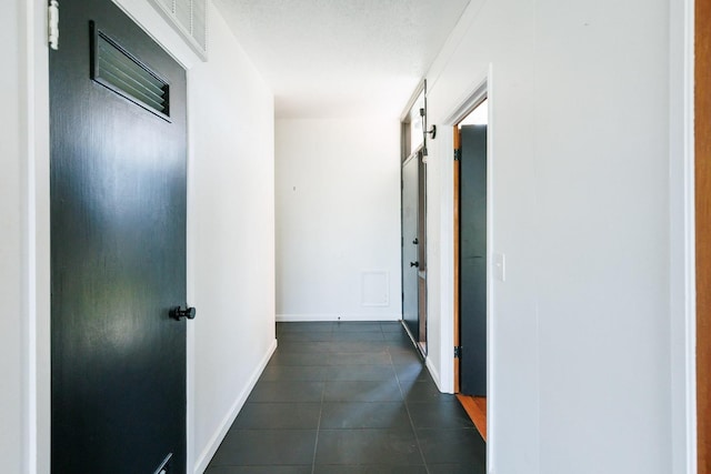 hall with dark tile patterned flooring