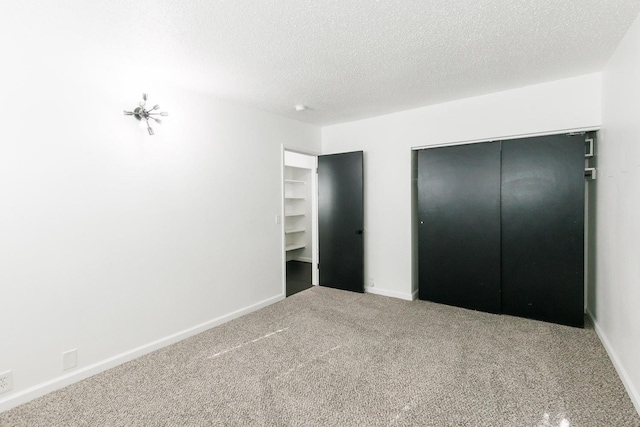 unfurnished bedroom featuring a closet, carpet floors, and a textured ceiling