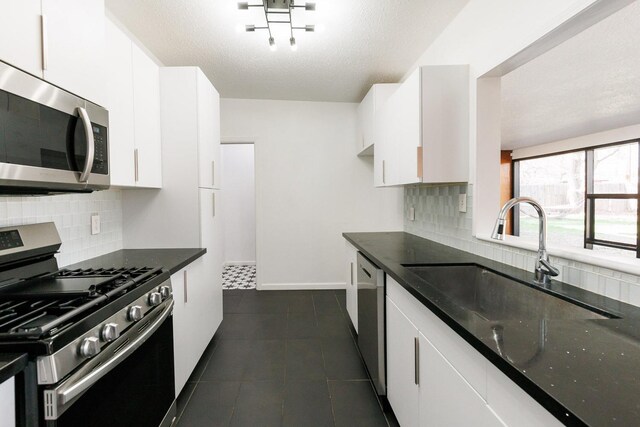 kitchen featuring tasteful backsplash, stainless steel appliances, sink, and white cabinets