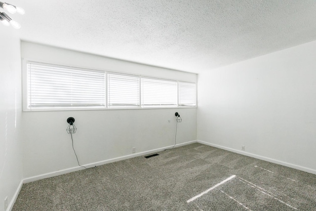 carpeted spare room featuring a textured ceiling