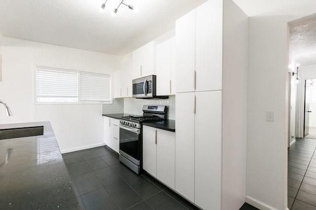 kitchen featuring white cabinetry, stainless steel appliances, sink, and tasteful backsplash