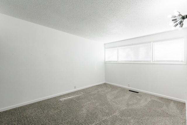 unfurnished room with carpet flooring and a textured ceiling