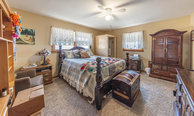 bedroom featuring baseboards, multiple windows, carpet, and a ceiling fan