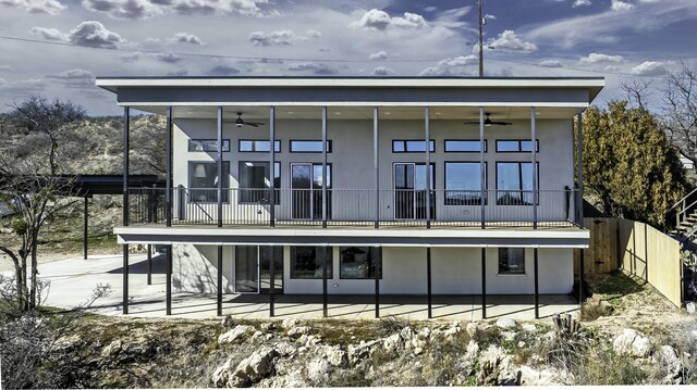 rear view of house featuring a patio area, a balcony, and ceiling fan