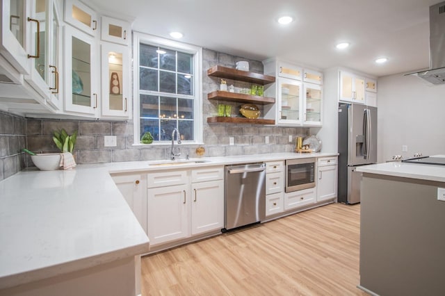 kitchen with sink, light hardwood / wood-style floors, white cabinets, and appliances with stainless steel finishes