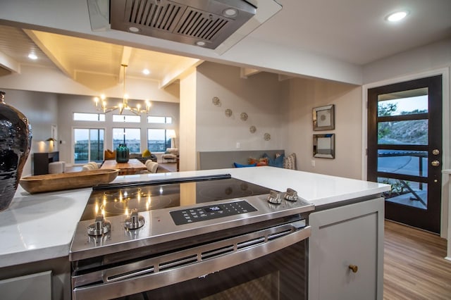 kitchen with an inviting chandelier, beam ceiling, stainless steel electric stove, and light hardwood / wood-style floors