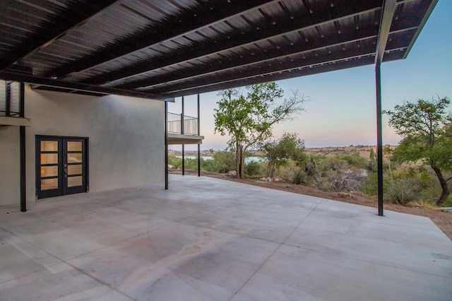 patio terrace at dusk with french doors and a balcony