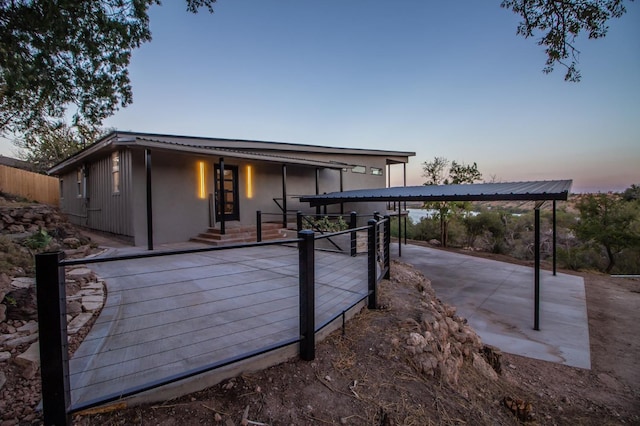 back house at dusk with a carport