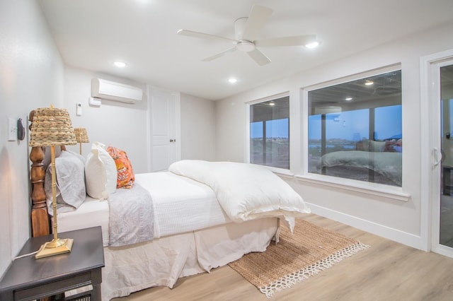 bedroom featuring light wood-type flooring, a wall mounted AC, and ceiling fan