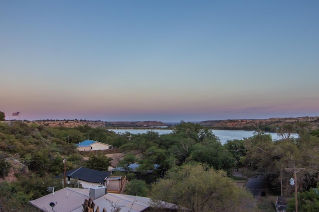 aerial view at dusk featuring a water view