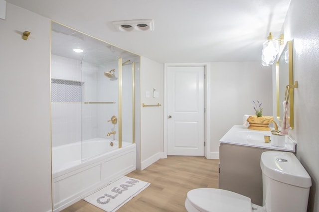 full bathroom with vanity, tiled shower / bath combo, wood-type flooring, and toilet