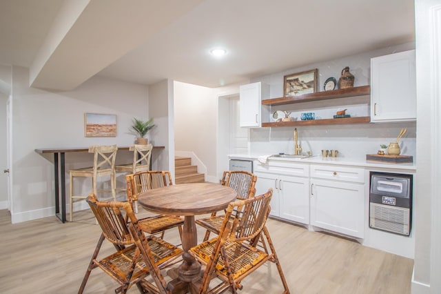 dining space with sink and light hardwood / wood-style floors