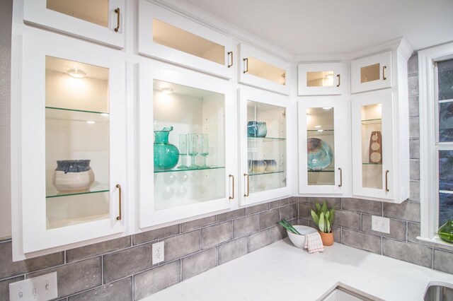 kitchen featuring white cabinets, backsplash, and stainless steel fridge with ice dispenser