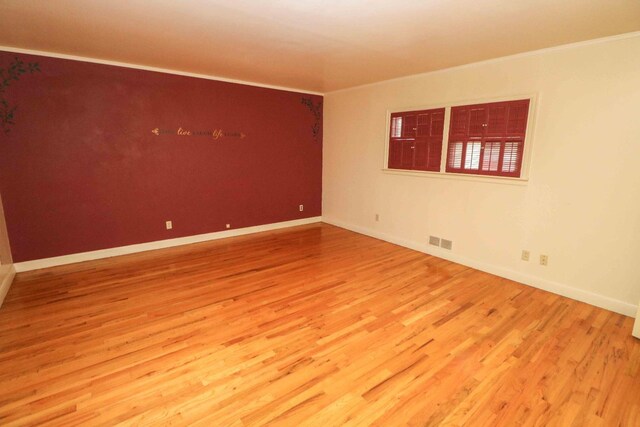 unfurnished room featuring crown molding and hardwood / wood-style floors