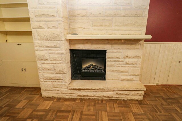 room details featuring a fireplace, parquet flooring, and wood walls