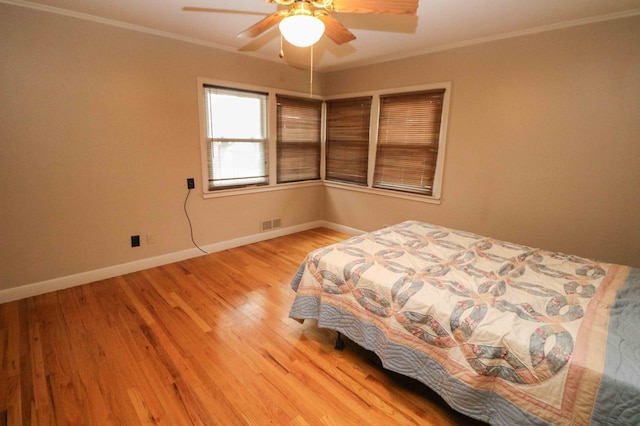 unfurnished bedroom featuring wood-type flooring, ornamental molding, and ceiling fan