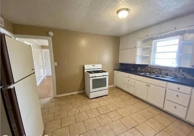 kitchen featuring sink, white cabinets, decorative backsplash, white appliances, and a textured ceiling