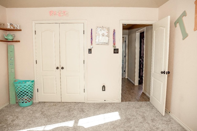 unfurnished bedroom featuring light carpet and a closet