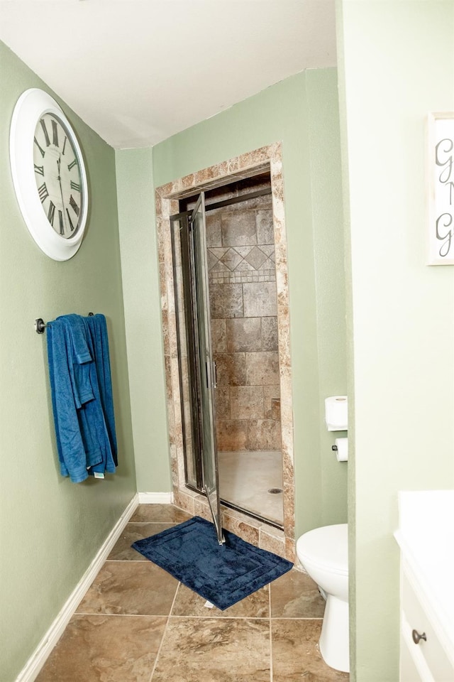 bathroom with vanity, toilet, and a shower with door