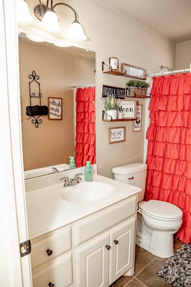 bathroom with a shower with curtain, vanity, tile patterned floors, and toilet