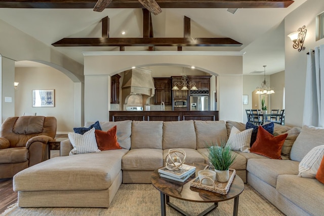 living room featuring beamed ceiling, a notable chandelier, high vaulted ceiling, and light hardwood / wood-style flooring