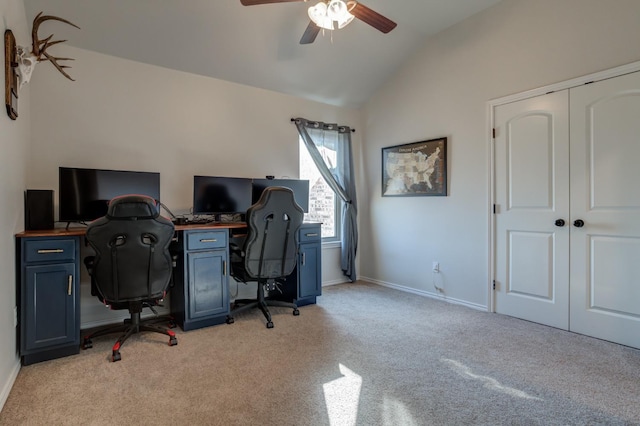 office area featuring vaulted ceiling, light carpet, and ceiling fan