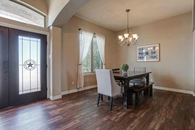 dining room with dark hardwood / wood-style floors and an inviting chandelier