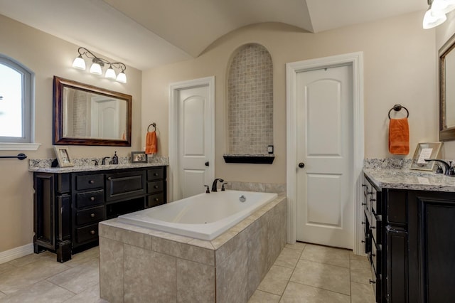 bathroom with vanity, tiled tub, and tile patterned flooring