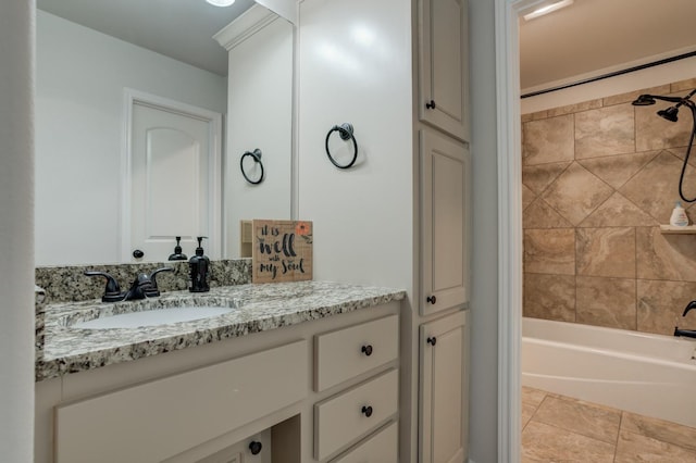 bathroom featuring tiled shower / bath combo, vanity, and tile patterned flooring