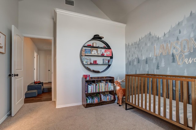 carpeted bedroom featuring a nursery area and vaulted ceiling