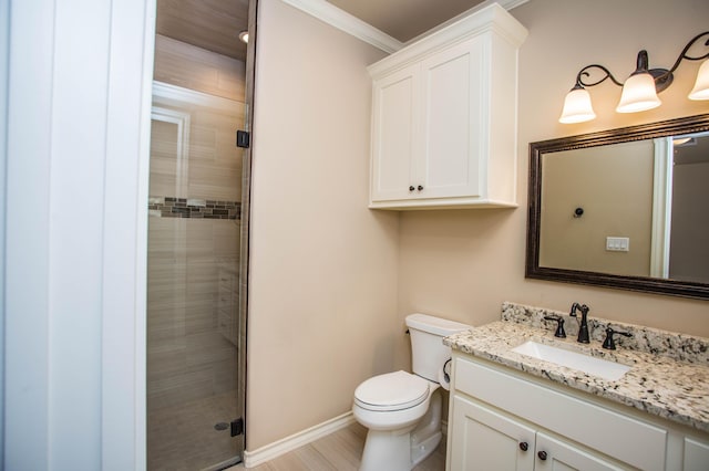 bathroom with toilet, vanity, baseboards, a stall shower, and crown molding